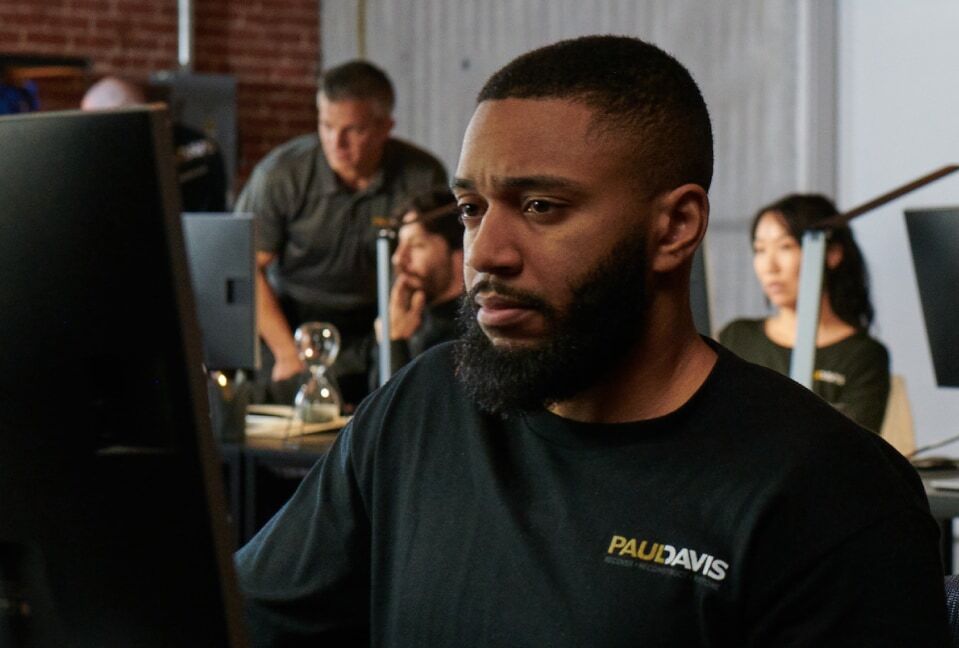 Paul Davis Restoration team member assisting customers on a computer at the Suburban Maryland and D.C. office